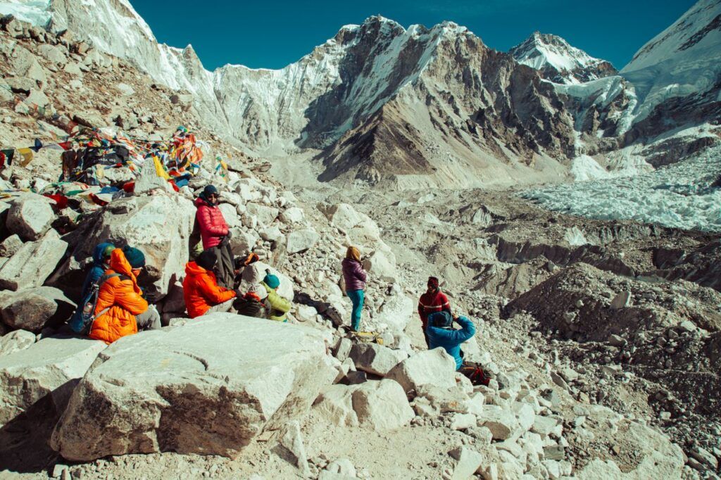 Senderistas descansando entre rocas en el campo base del Everest, en Nepal