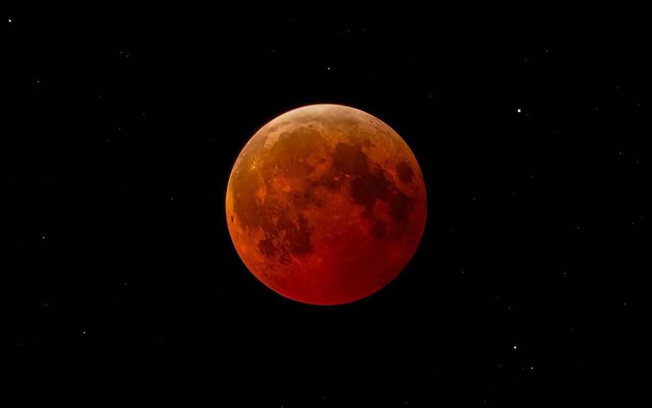 Luna de sangre durante un eclipse lunar total en un cielo estrellado