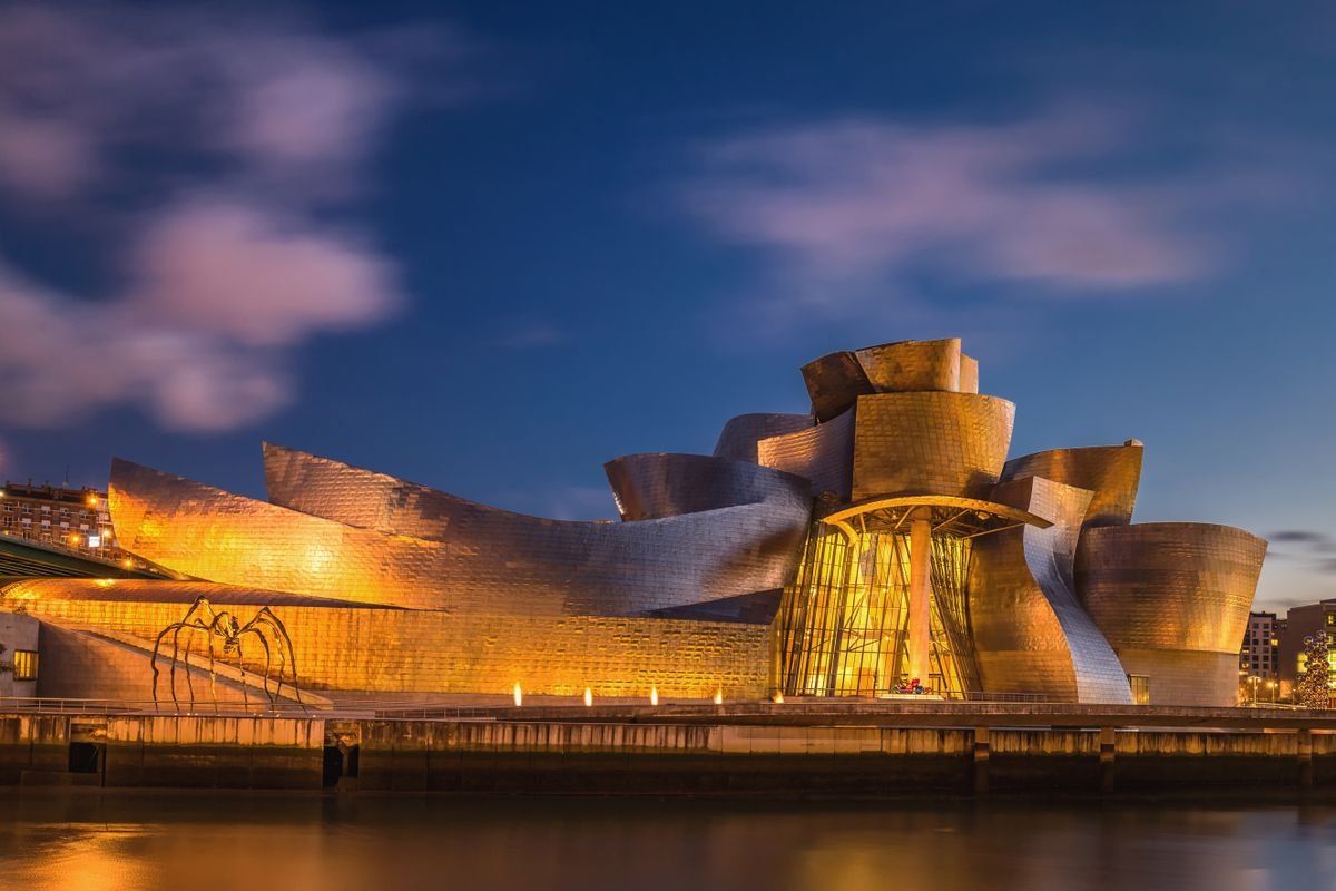 Museo Guggenheim iluminado al atardecer junto a la ría