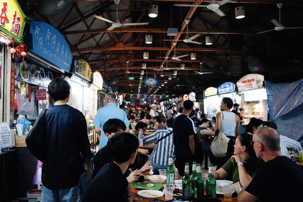 Puestos de comida y mesas llenas de gente en Maxwell Food Centre
