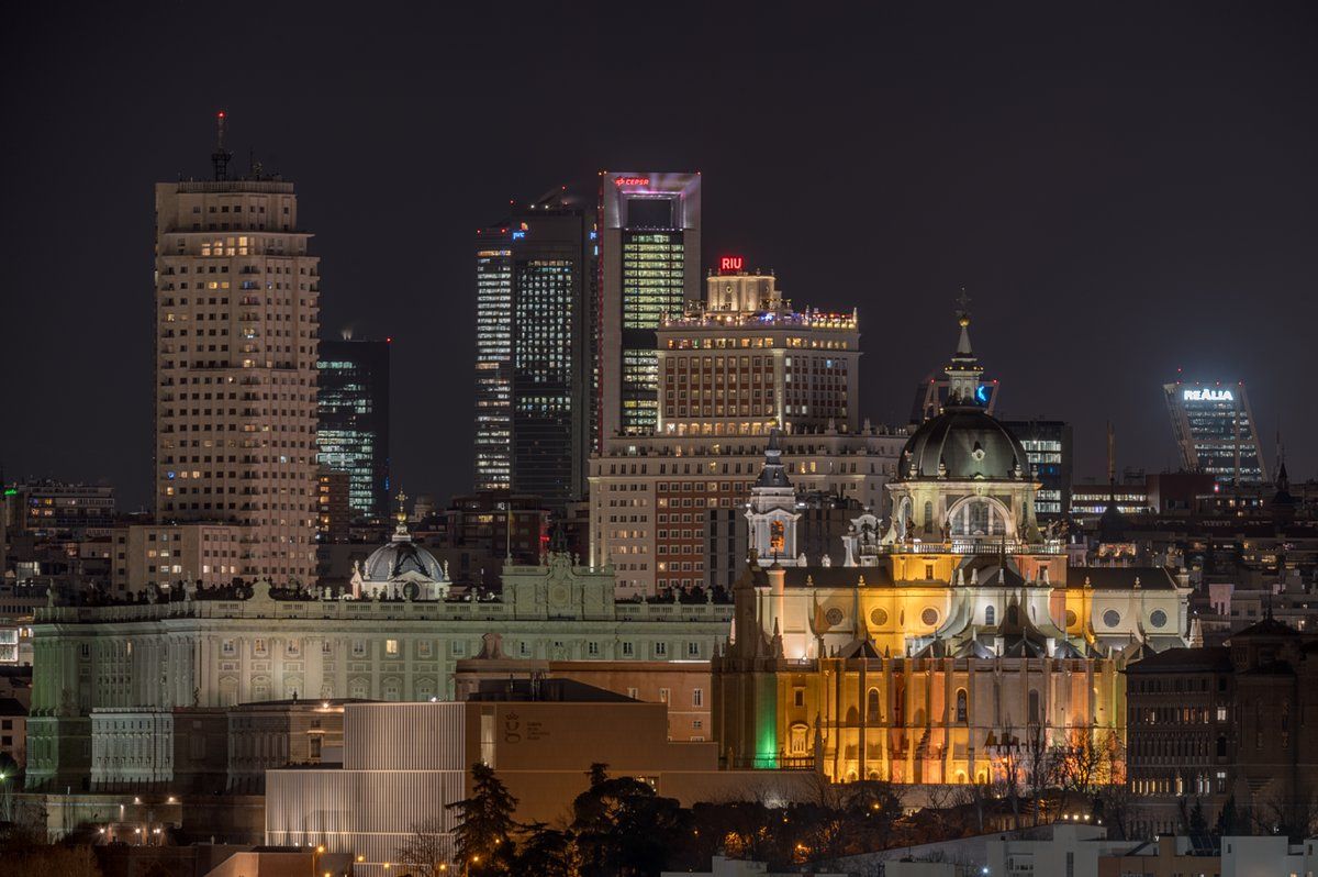 Skyline nocturno de Madrid con edificios iluminados y cúpula en primer plano