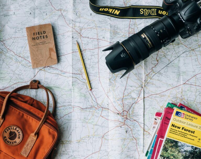 Mapa, cámara, libreta y mochila listos para planificar un viaje